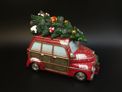 WOOD PANELED STATION WAGON WITH DECORATED CHRISTMAS TREE ON TOP